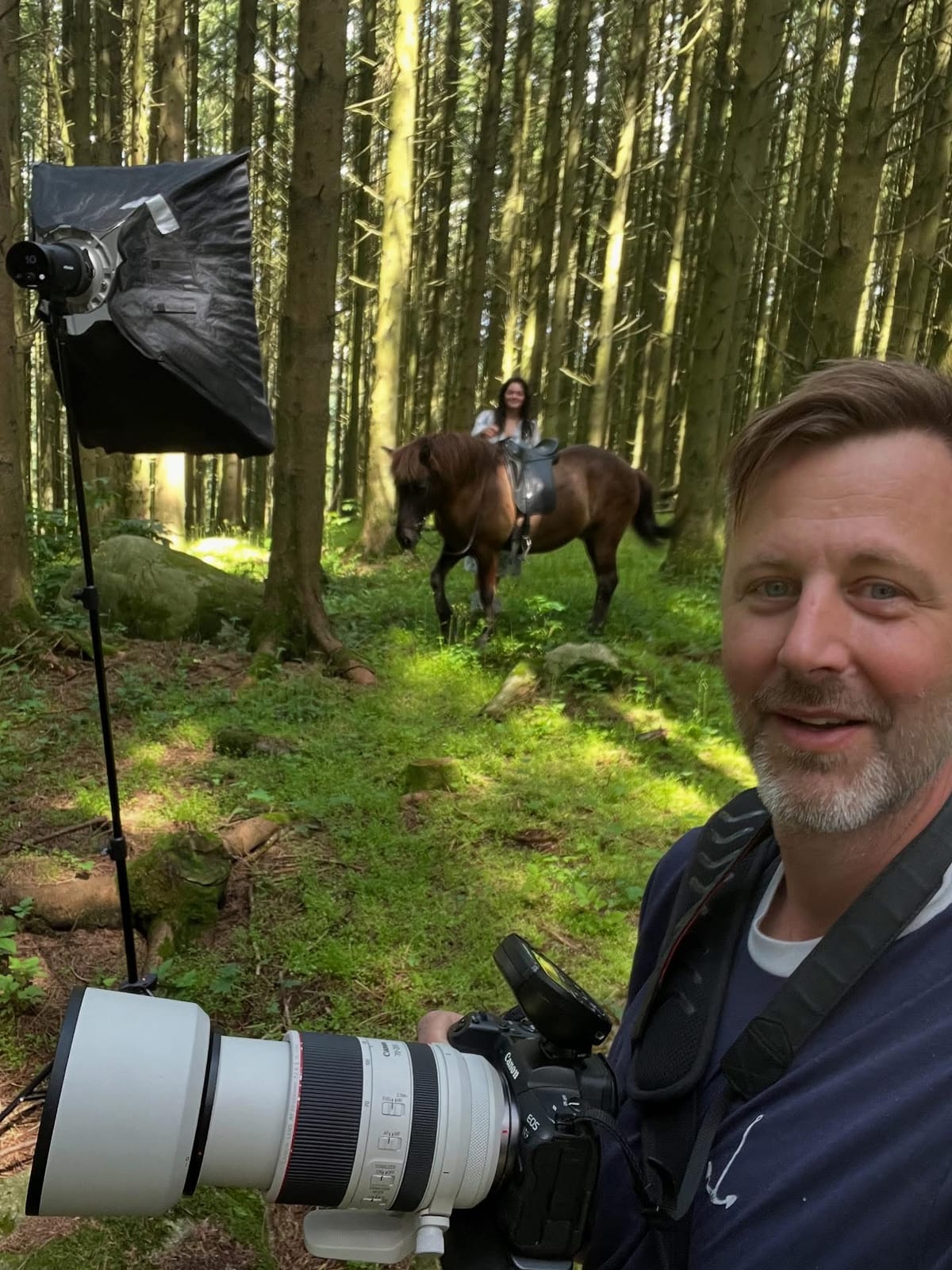 Marius Vervik på fotooppdrag i skogen, med kamera og softboks