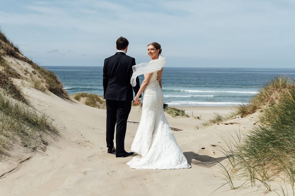 Karina og Magnus går mot havet gjennom sanddynene, hun ser bakover